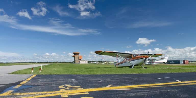 Runway at Villeneuve Airport, with small airplane in background