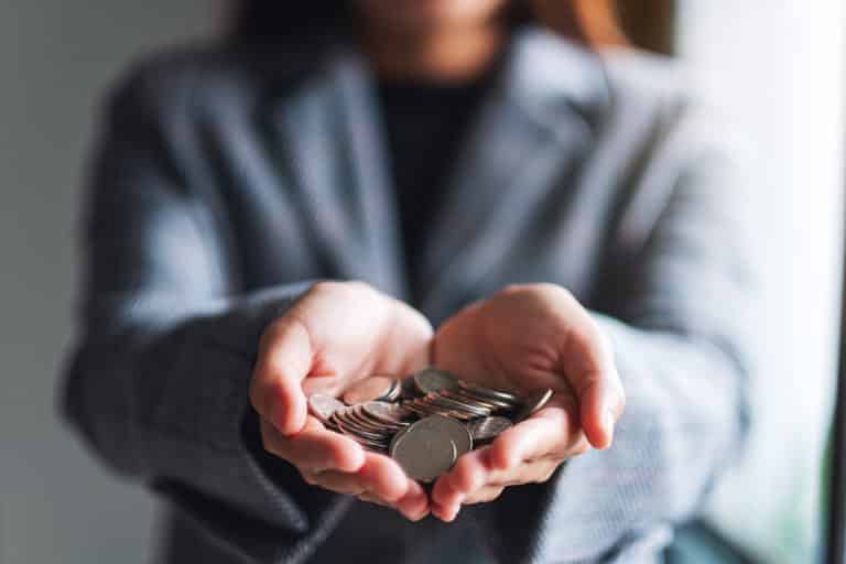 Person holding coins in their outstretched hands.