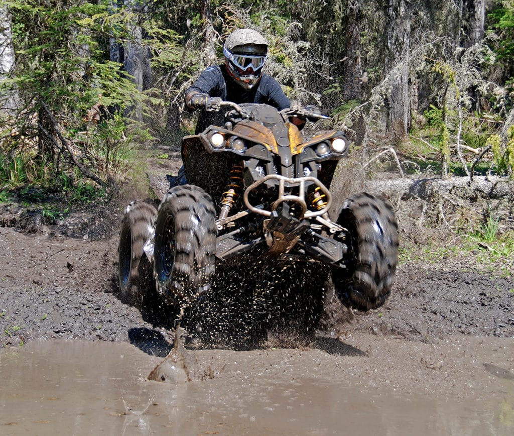 Off-highway vehicle is driven through the mud.