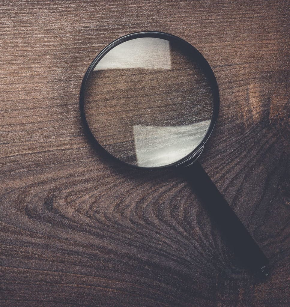 Magnifying glass on wood background