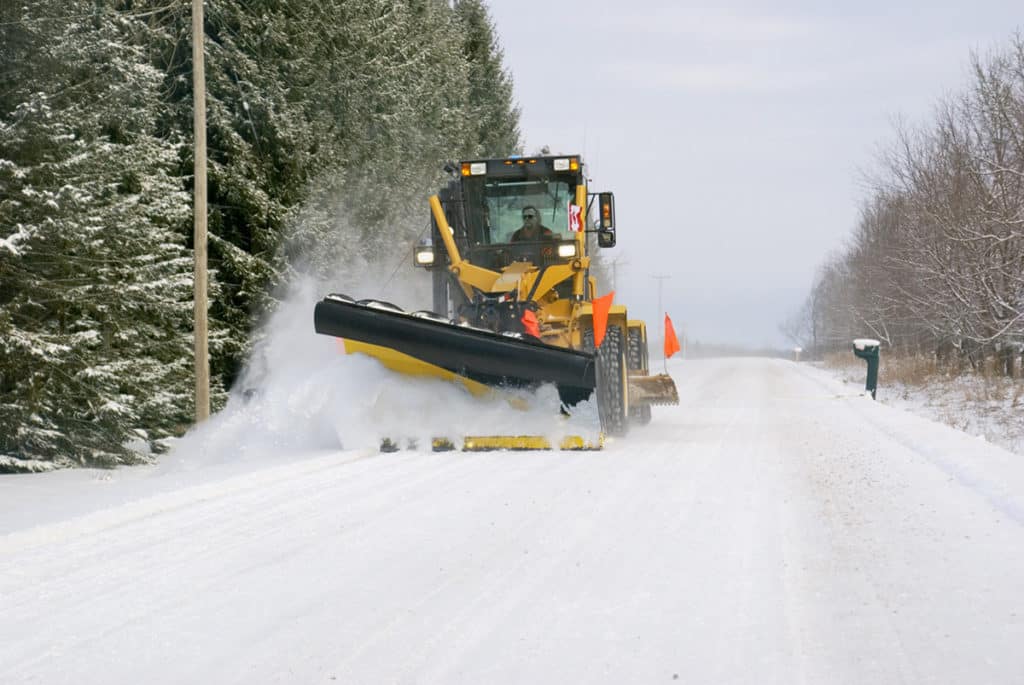 Snow plow clearing snow from roadway