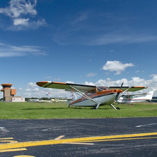 Runway at Villeneuve Airport, with small airplane in background